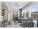 Bright sitting room with two chairs, geometric rug, ceiling fan, and large sunny windows at 2170 Biller Cir, The Villages, FL 32163