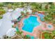 Aerial view of a pool area with lounge chairs, umbrellas, and a playground nearby at 2310 Silver Palm Dr # 301, Kissimmee, FL 34747