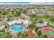 Community aerial view featuring a pool, clubhouse, splash pad, playground, and tennis courts amidst lush landscaping at 2310 Silver Palm Dr # 301, Kissimmee, FL 34747