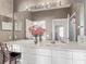 Bathroom vanity with large mirrors, white cabinets and drawers, and decorative flowers at 2310 Silver Palm Dr # 301, Kissimmee, FL 34747