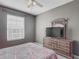 Comfortable bedroom with neutral walls, ceiling fan, window, dresser, and a cozy bed at 2310 Silver Palm Dr # 301, Kissimmee, FL 34747
