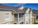 Exterior of a tan building with a screened balcony under a cloudy blue sky at 2310 Silver Palm Dr # 301, Kissimmee, FL 34747