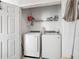 Laundry room with white washer and dryer units, wire rack and storage space at 2310 Silver Palm Dr # 301, Kissimmee, FL 34747