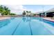 A clear, sparkling pool with lane dividers, lounge chairs, and a nearby clubhouse at 2310 Silver Palm Dr # 301, Kissimmee, FL 34747