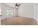 Neutral bedroom with large window, fan and neutral carpet at 2461 Merida Cir, The Villages, FL 32162