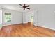 This bedroom features hardwood floors and a bright window with a view of the neighborhood at 2461 Merida Cir, The Villages, FL 32162