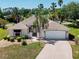 Well-maintained exterior of a charming home, featuring a manicured lawn and a two-car garage on a sunny day at 2461 Merida Cir, The Villages, FL 32162