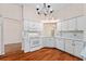 Well-lit kitchen with white appliances, light countertops, and ample cabinet space on wood floors at 2461 Merida Cir, The Villages, FL 32162