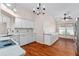 Bright kitchen with white cabinetry, marble countertops, and modern appliances adjacent to the living room at 2461 Merida Cir, The Villages, FL 32162