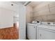 Well-equipped laundry room with modern washer and dryer, storage shelves, and natural lighting at 2461 Merida Cir, The Villages, FL 32162