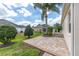 Paver patio and verdant lawn in a well-maintained backyard with mature landscaping and clear blue skies at 278 Matisse Ave, The Villages, FL 32162