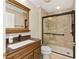 Bathroom features a walk-in shower with glass doors and vanity with framed mirror at 278 Matisse Ave, The Villages, FL 32162