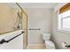 Well-lit bathroom featuring a glass-enclosed shower, toilet, and window with natural light at 278 Matisse Ave, The Villages, FL 32162