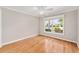 Bedroom featuring hardwood floors, a ceiling fan, and a large window with neighborhood views at 278 Matisse Ave, The Villages, FL 32162