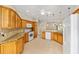 Well-equipped kitchen featuring tile flooring, wood cabinets, granite countertops, and stainless steel appliances at 278 Matisse Ave, The Villages, FL 32162