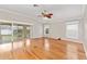 Spacious living room with hardwood floors, fan, vaulted ceiling, and sliding glass doors providing natural light at 278 Matisse Ave, The Villages, FL 32162