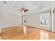 Bright main bedroom featuring hardwood floors, tray ceiling with fan, and lots of natural light at 278 Matisse Ave, The Villages, FL 32162
