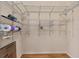 Walk-in closet with custom metal shelving and laminate wood flooring at 278 Matisse Ave, The Villages, FL 32162