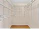 Organized walk-in closet with white wire shelving, providing ample storage space. Hardwood floor at 278 Matisse Ave, The Villages, FL 32162