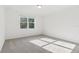 Sunlit bedroom featuring neutral carpet and a large window at 28078 Poppy Ct, Leesburg, FL 34748