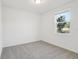 Neutral bedroom with carpet flooring, a window providing natural light, and fresh white paint at 28078 Poppy Ct, Leesburg, FL 34748