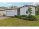 Well-kept home showcasing a lush green lawn, mature landscaping, and a side-entry two-car garage at 28078 Poppy Ct, Leesburg, FL 34748