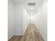 Bright hallway featuring recessed lighting, wood-look floors, and white walls leading to the front door at 28078 Poppy Ct, Leesburg, FL 34748