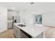 Kitchen features an island with stainless sink, gray cabinets, stainless appliances, and backyard view at 28078 Poppy Ct, Leesburg, FL 34748