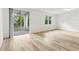 Bright, open living area featuring wood-look floors, a sliding glass door, and views of the outdoor patio at 28078 Poppy Ct, Leesburg, FL 34748