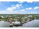 Stunning aerial view of a lighthouse, docks, and lake surrounded by lush greenery under a beautiful blue sky with clouds at 299 Jefferson Ln, The Villages, FL 32162