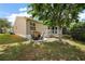 Charming backyard with patio seating area under mature shade tree at 299 Jefferson Ln, The Villages, FL 32162