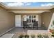 Relaxing front porch with seating, enhanced by beautiful landscaping and decorative brickwork at 299 Jefferson Ln, The Villages, FL 32162