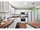 Well-lit kitchen showcasing white cabinetry, wood counters, stainless appliances and eat-in island at 299 Jefferson Ln, The Villages, FL 32162