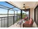 A screened balcony with comfortable seating and a ceiling fan overlooking a beautiful lake view at 3011 Lake Woodward Dr, Eustis, FL 32726