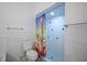 Bathroom featuring a toilet, towel rack, and walk-in shower with black and white tile and a patterned shower curtain at 3011 Lake Woodward Dr, Eustis, FL 32726