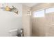 Bathroom features tiled walls, shower with a window, toilet, decor, and space for toiletries, providing comfort and functionality at 3011 Lake Woodward Dr, Eustis, FL 32726