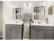 This well-lit bathroom features dual sinks, gray cabinets, a full-length mirror, and contemporary lighting fixtures at 3011 Lake Woodward Dr, Eustis, FL 32726