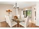 Bright dining room featuring a glass table, white chairs, and natural light from the window at 3011 Lake Woodward Dr, Eustis, FL 32726