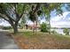 Charming waterfront property with mature trees, a spacious lawn, and serene lake views at 3011 Lake Woodward Dr, Eustis, FL 32726