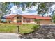 Well-maintained front yard with lush landscaping, mature trees, and a charming home with a welcoming entrance at 3011 Lake Woodward Dr, Eustis, FL 32726
