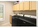 Laundry room with modern appliances and ample cabinet space, providing a functional and organized area at 3011 Lake Woodward Dr, Eustis, FL 32726
