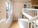 A naturally lit staircase with white banisters leads to a living area with floor to ceiling windows and hardwood flooring at 3011 Lake Woodward Dr, Eustis, FL 32726