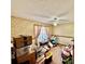 A messy bedroom with floral wallpaper, window with pink curtains, desk, ceiling fan, and lots of boxes at 3051 Newmark Dr, Deltona, FL 32738