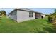 Spacious backyard featuring a well-manicured lawn and enclosed porch at 3203 Islawild Way, The Villages, FL 32163