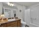Well-lit bathroom with modern sink and cabinet and a full shower and tub at 3203 Islawild Way, The Villages, FL 32163