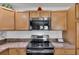 Kitchen features stainless steel range, microwave and ample cabinet storage at 3203 Islawild Way, The Villages, FL 32163