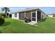 The house features a screened patio with a grill and a manicured lawn at 3203 Islawild Way, The Villages, FL 32163