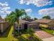 Charming single-story home with a well-manicured lawn, palm trees, and a brick-paved driveway at 3654 Limestone St, Clermont, FL 34711