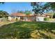 Single story home features a well-kept lawn, mature trees, and a classic brick exterior with a two-car garage at 36545 Scottsdale Dr, Grand Island, FL 32735
