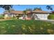 Charming single story home boasts a well-manicured lawn and a classic brick facade with a two car garage at 36545 Scottsdale Dr, Grand Island, FL 32735